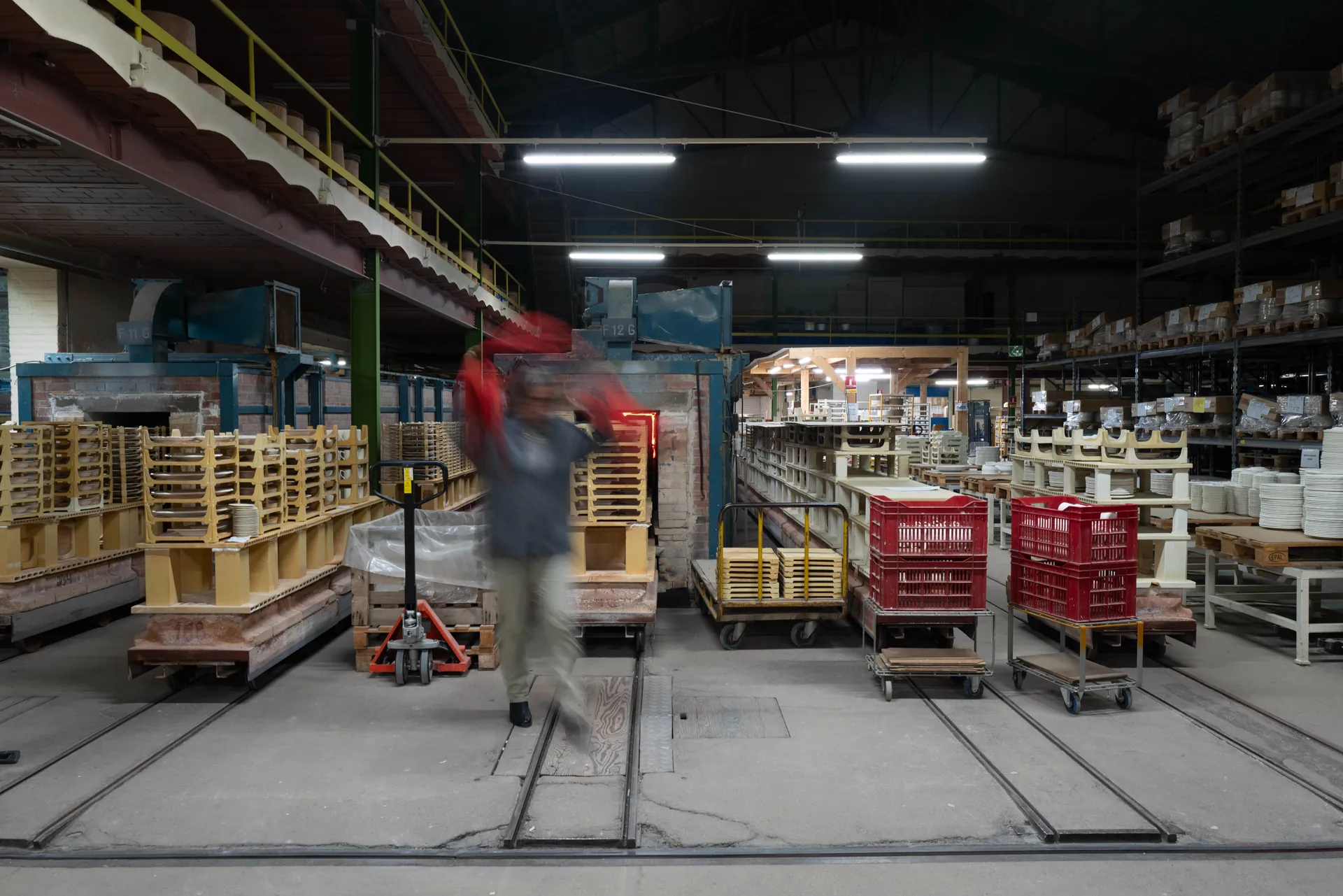 Engrenage métallique et manche en bois d'une machine ancienne, silhouette floue d'un ouvrier