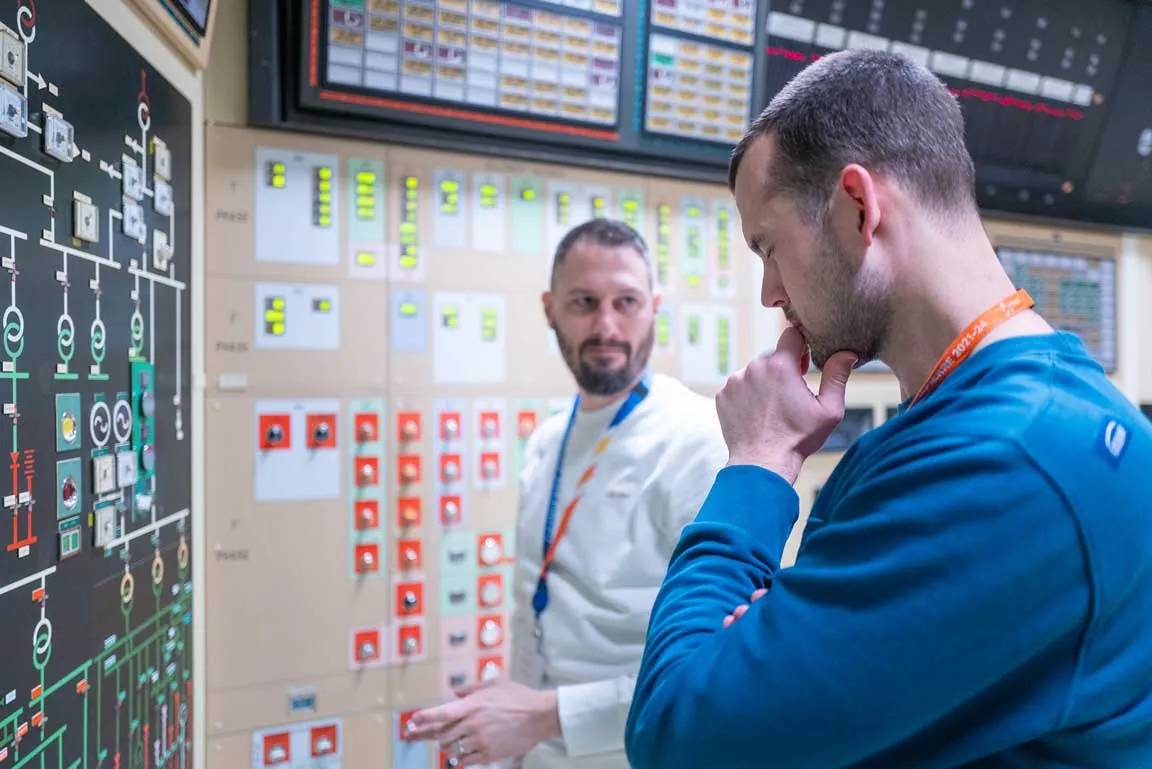 Opératrice en salle de commande d'une centrale nucléaire, tableau de bord panoramique
