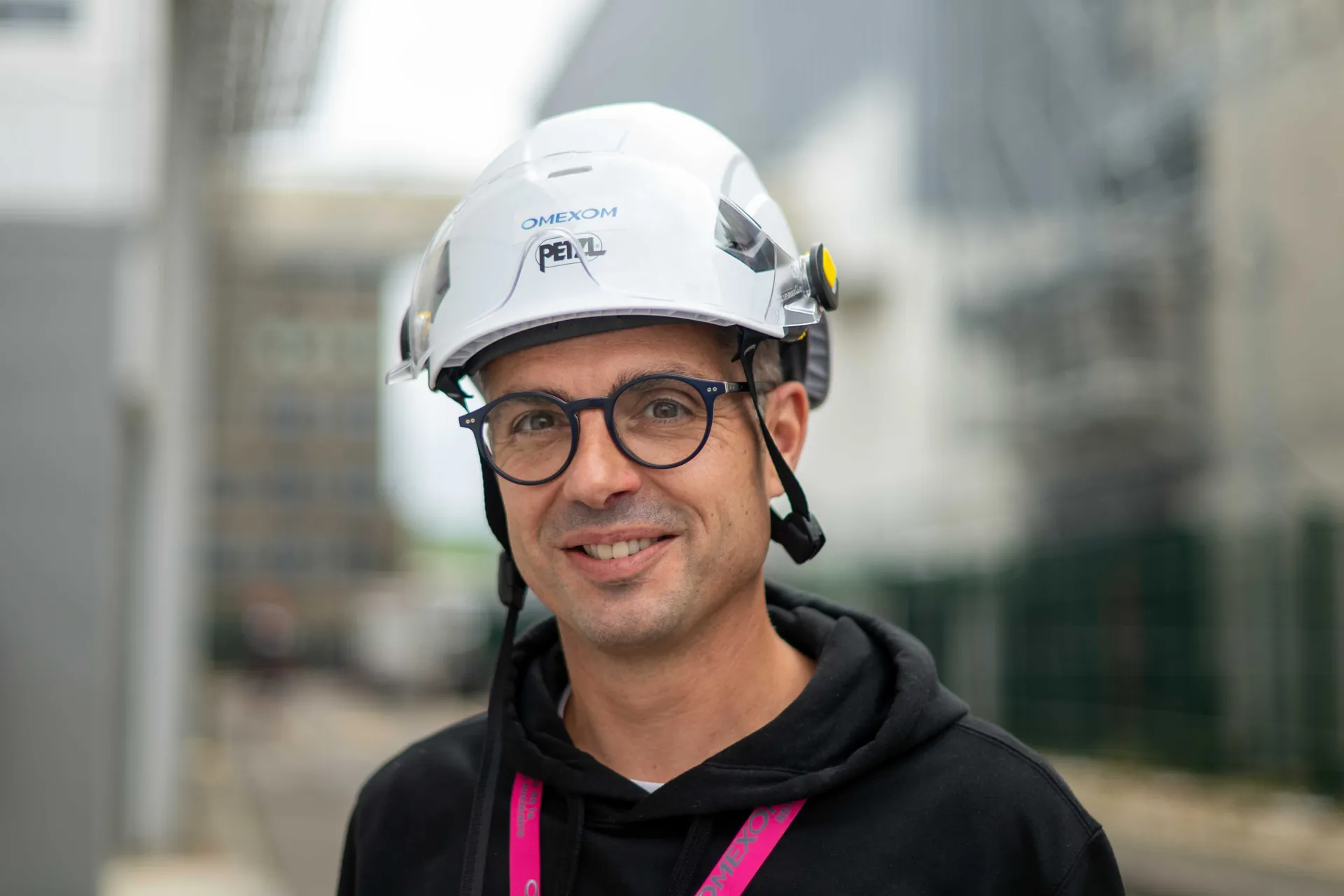 Portrait serré d'un jeune technicien aux yeux clairs devant des plans techniques de réacteur nucléaire