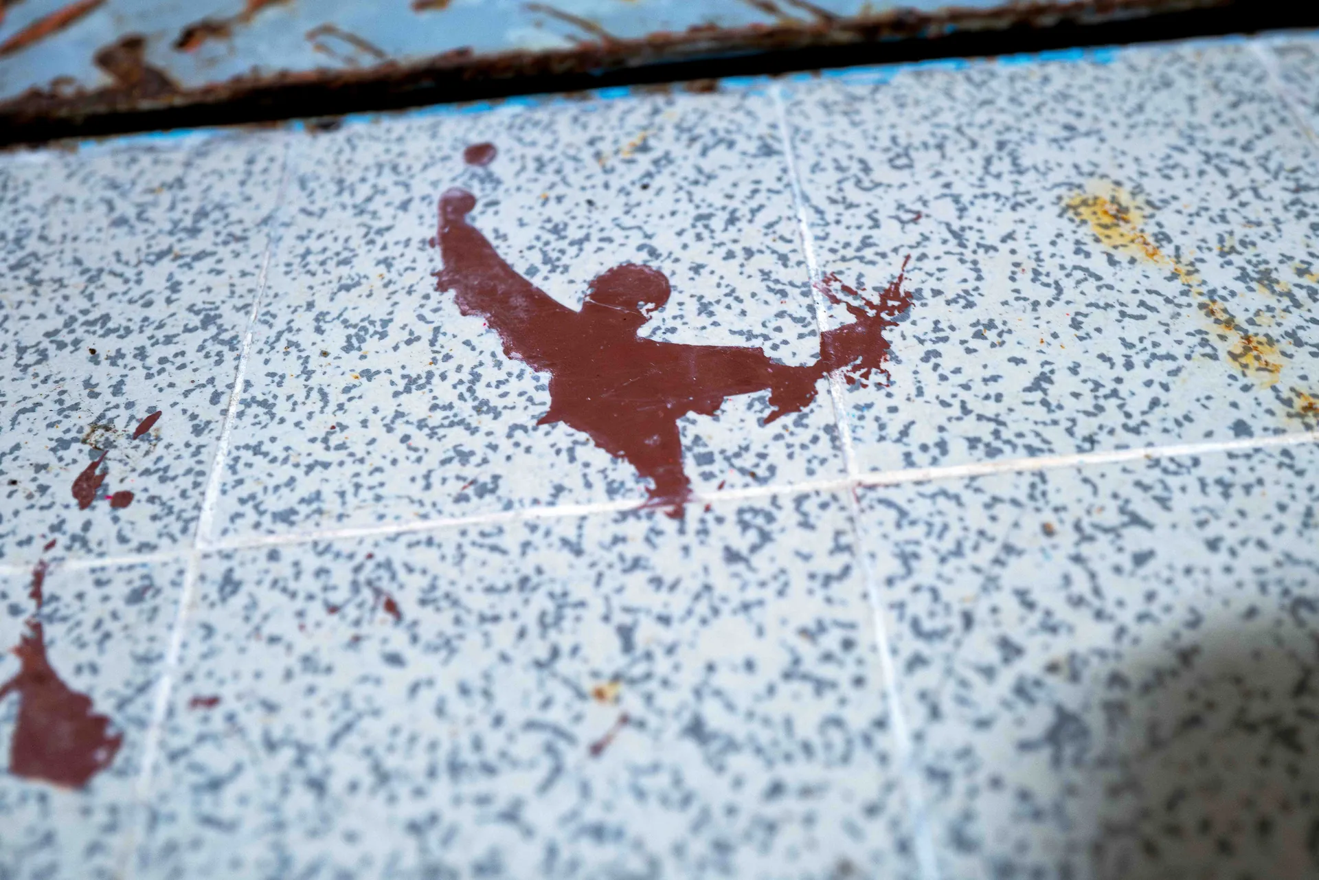 Plume blanche pos&eacute;e sur surface m&eacute;tallique &agrave; peinture bleue &eacute;caill&eacute;e