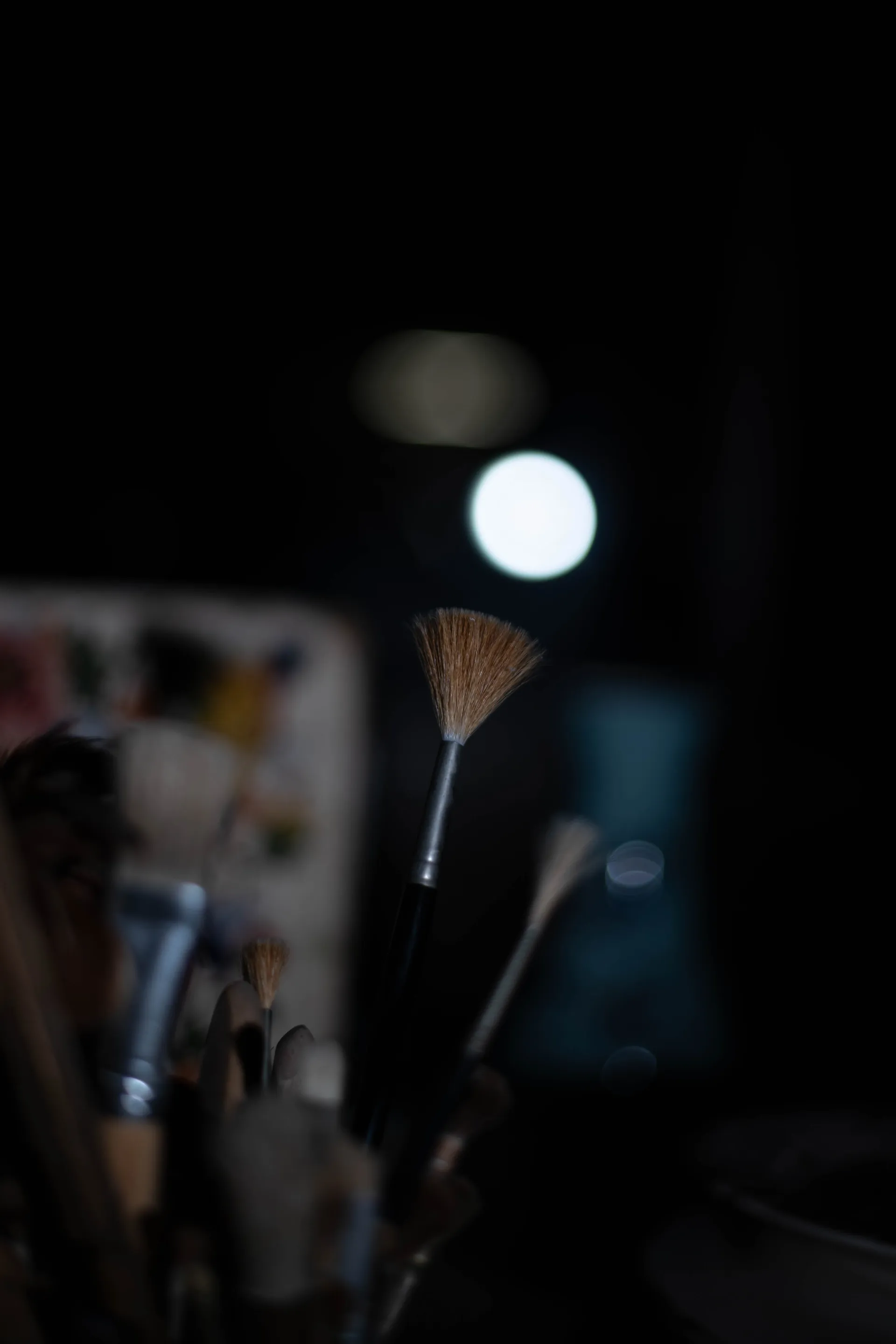 Gros plan abstrait sur une pile d'assiettes en faïence dans la pénombre, jeux de reflets