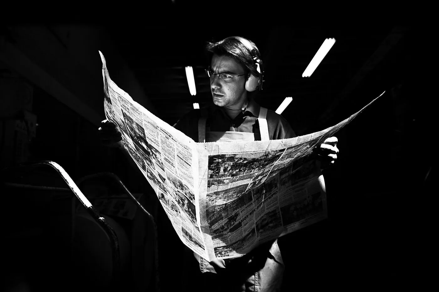 Détail d'encre noire coulant sur un rouleau de la rotative, matière brillante et épaisse