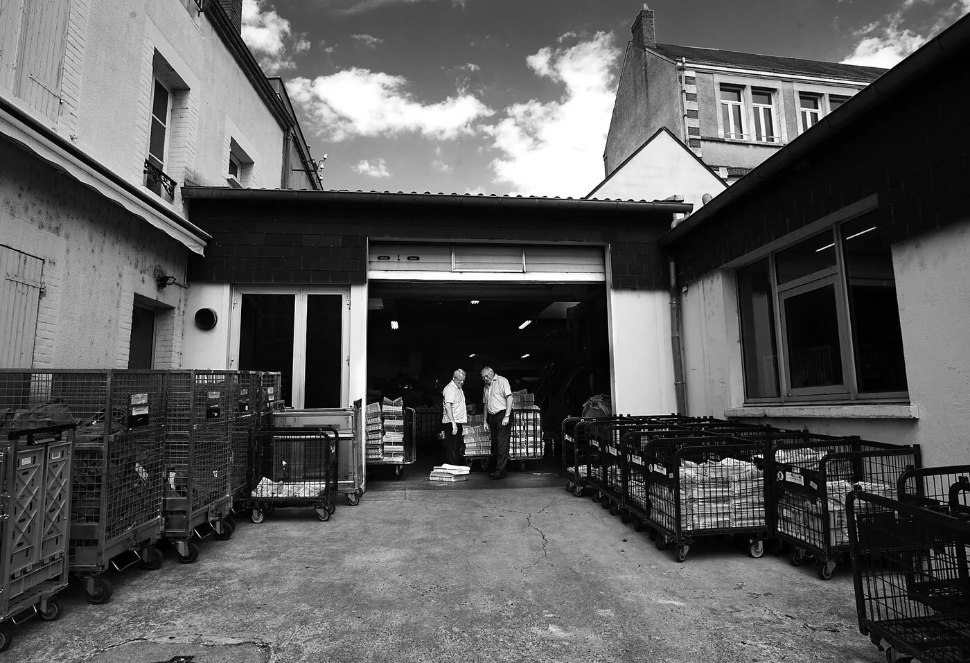 Cour de l'imprimerie du Journal de Gien, chariots de journaux prêts à l'expédition