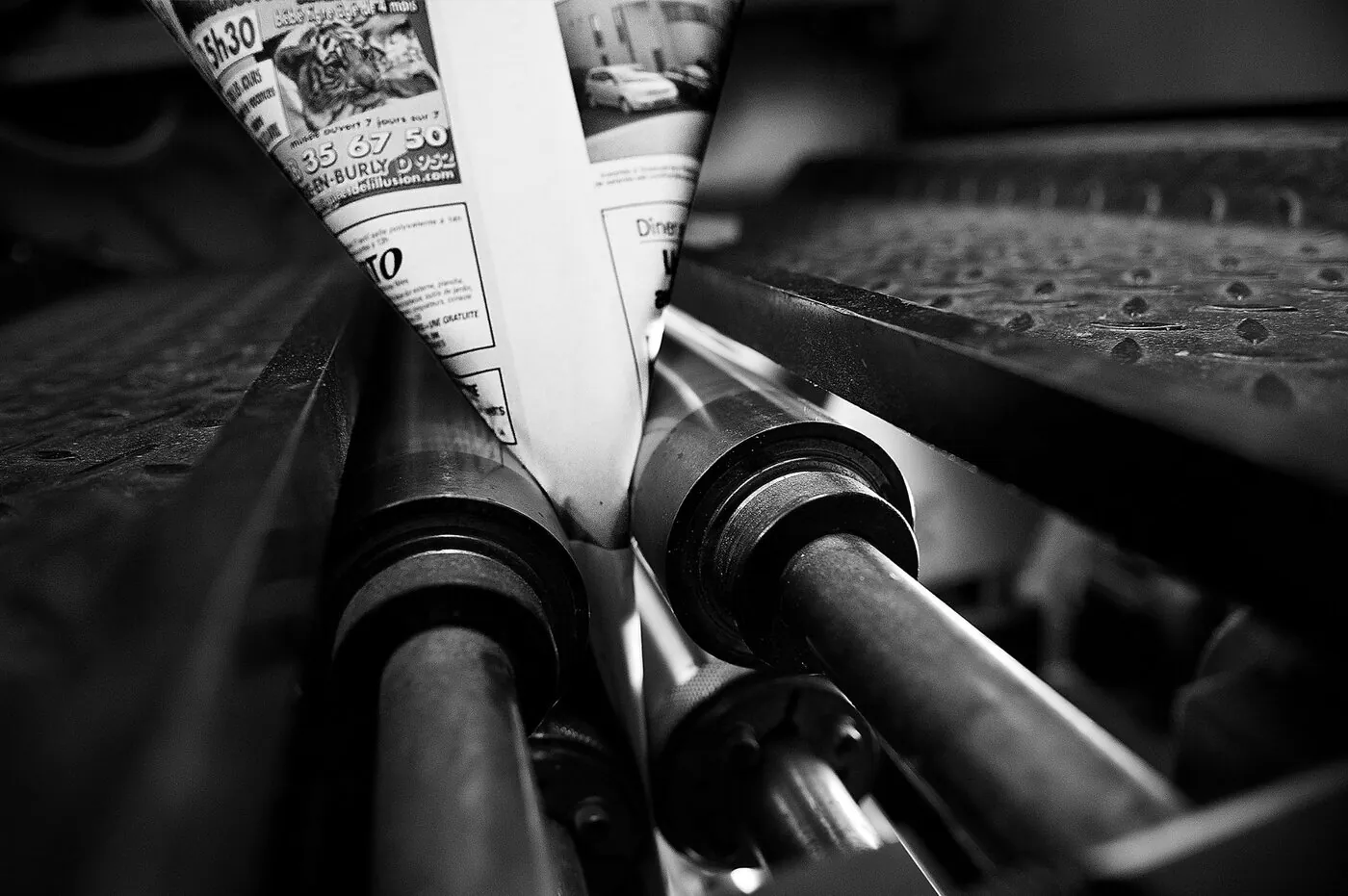 Papier journal en mouvement sur la presse, flou de vitesse et vis métallique