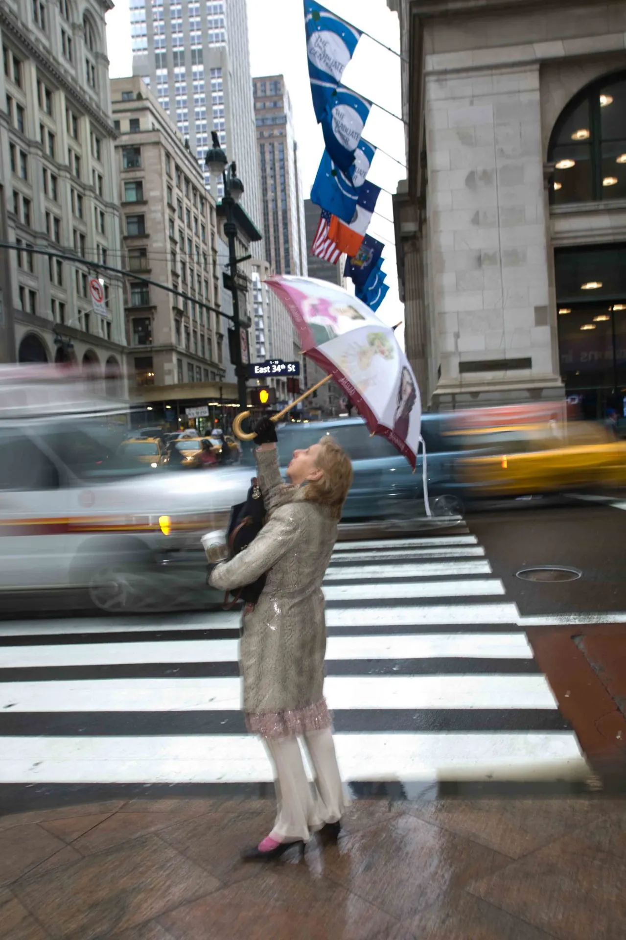 Silhouette floue au parapluie traversant un passage piéton de Manhattan sous la pluie