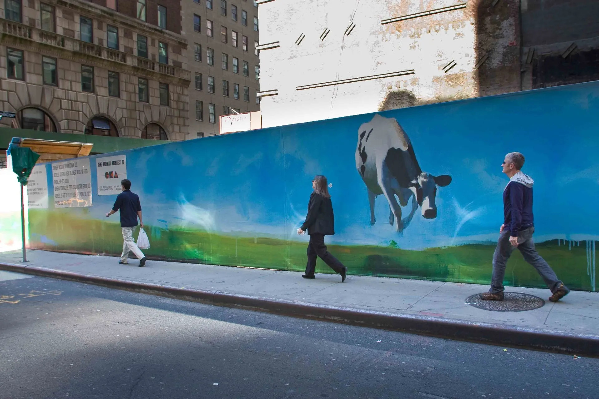 Passant longeant une fresque murale verte dans une rue de New York