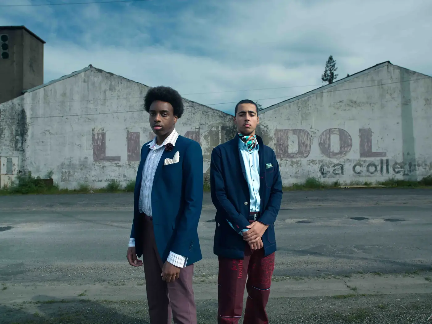 Basketteur en costume sur une route, immeubles en arrière-plan, direction artistique Benny Tonda