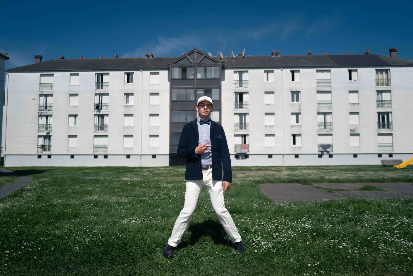 Basketteur sapeur marchant devant des barres d'immeubles, costume et ballon