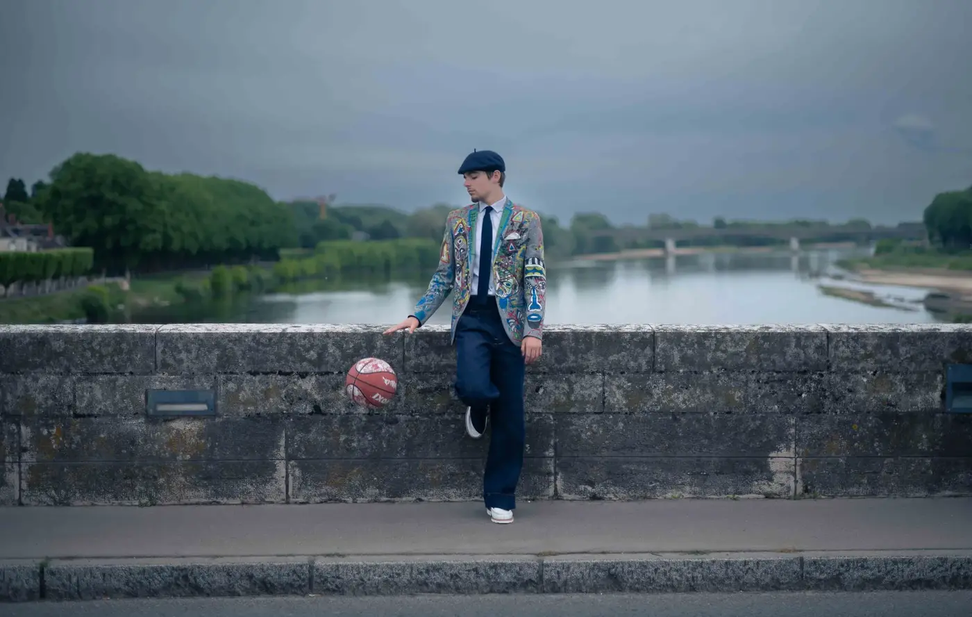 Basketteur sapeur posant sur un muret au bord de la Loire, ville en arrière-plan